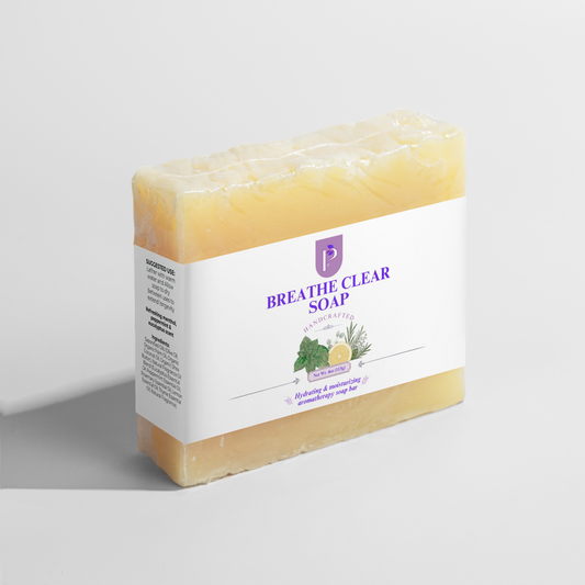 A bar of Breathe Clear Soap by Natural Apothecary, featuring a white label with purple text and botanical illustrations, wrapped in clear plastic on a light gray background.