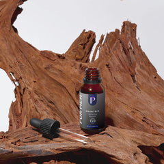 A small amber glass dropper bottle labeled 'FURTHER MAINTAIN Moisturizing Serum' stands on a piece of weathered brown wood, with a black dropper lying beside it against a light gray background.
