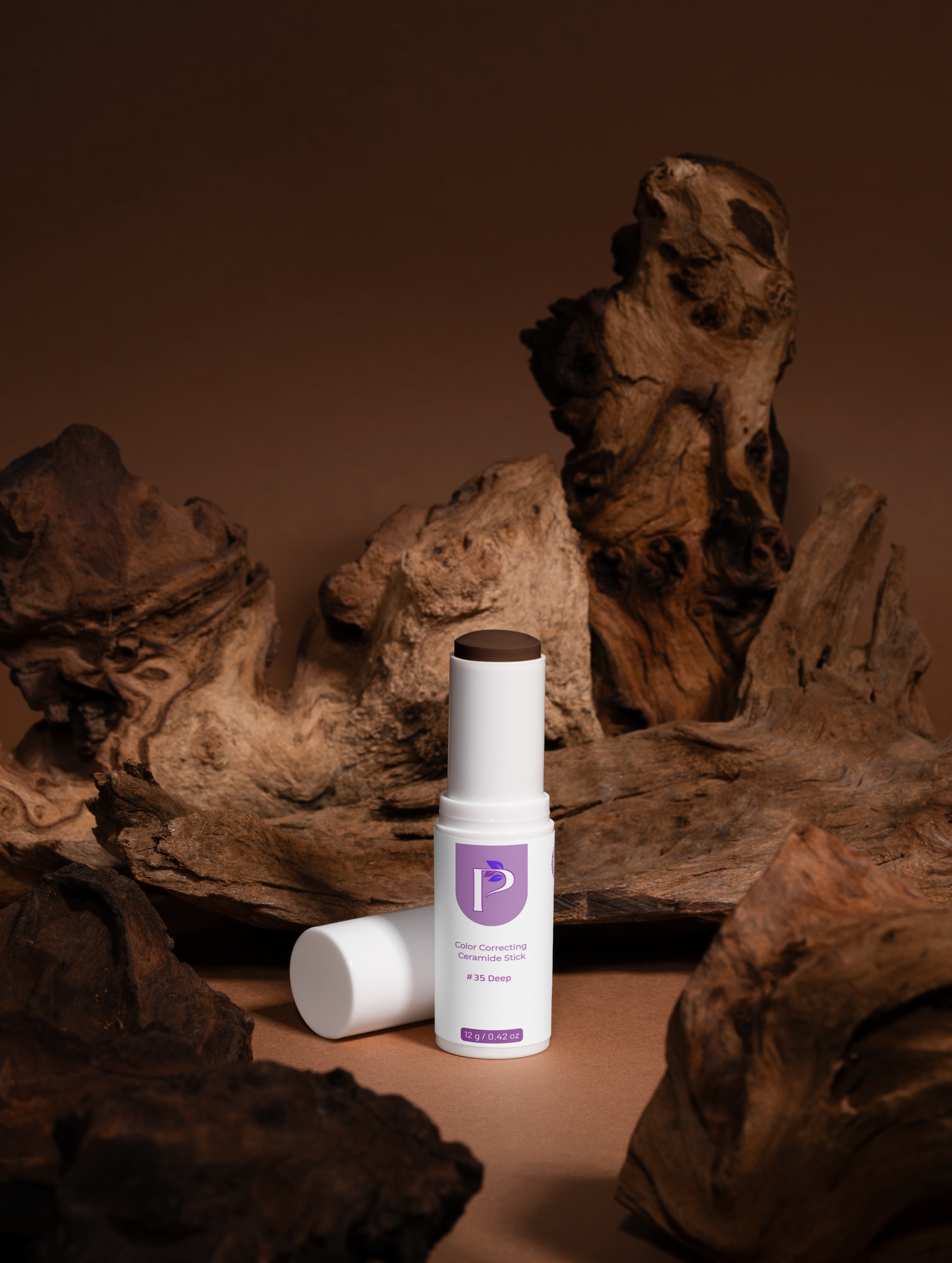 Cosmetic stick with wooden cap on a brown background