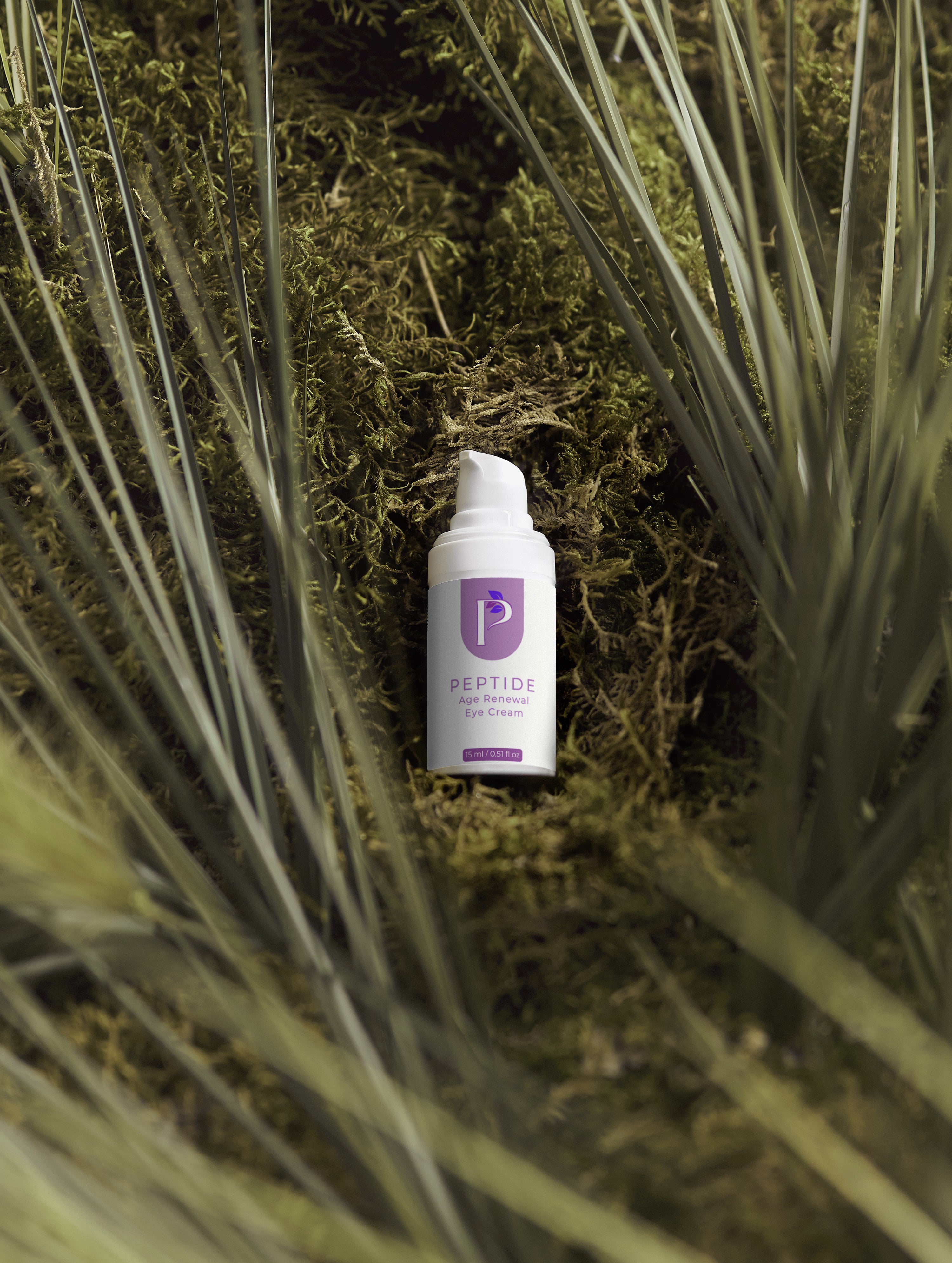 A small white skincare bottle labeled 'PEPTIDE REPAIR CREAM' with a purple logo, placed on dark moss surrounded by tall grass blades.