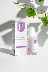 A skincare product set featuring a white box and a clear bottle with a white pump dispenser, labeled 'RADIANCE REPAIR SERUM' with a purple logo, styled on a white surface with green leaves casting shadows.